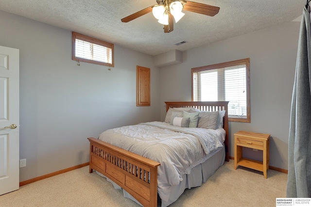 bedroom featuring multiple windows, light colored carpet, visible vents, and baseboards