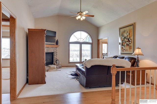 living room featuring baseboards, lofted ceiling, ceiling fan, and a fireplace