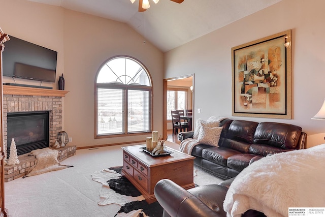 living area with lofted ceiling, a ceiling fan, carpet floors, baseboards, and a brick fireplace