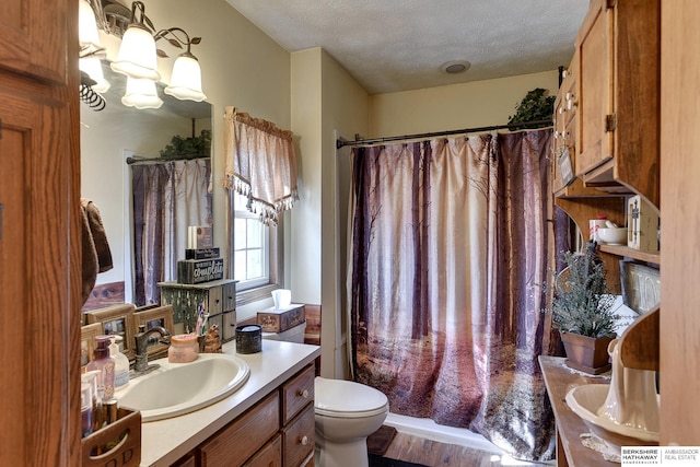 bathroom featuring vanity, a textured ceiling, curtained shower, toilet, and a chandelier