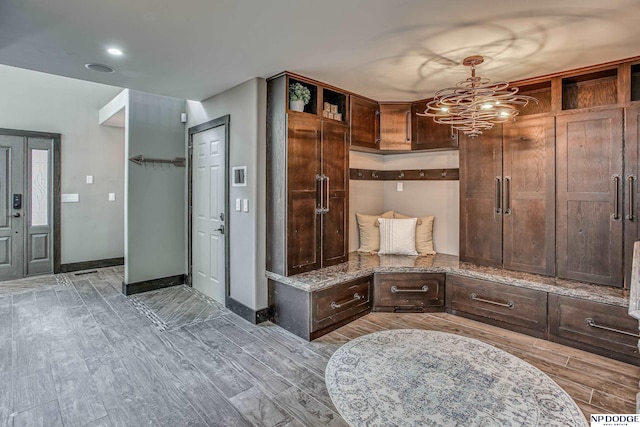 mudroom with wood finish floors, baseboards, and a chandelier