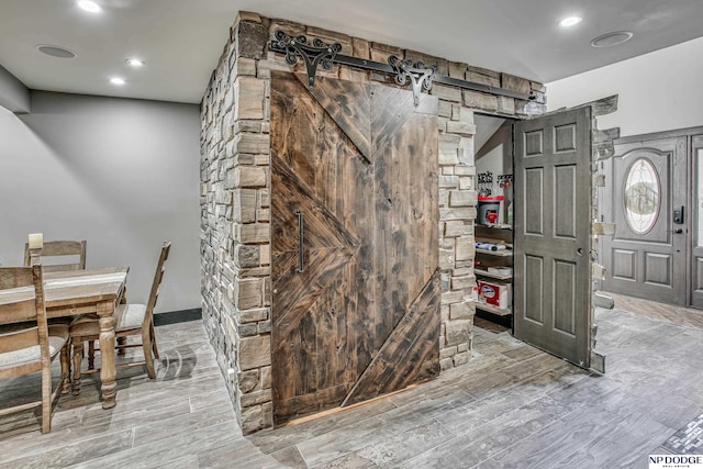 interior space featuring a barn door, recessed lighting, and wood finished floors