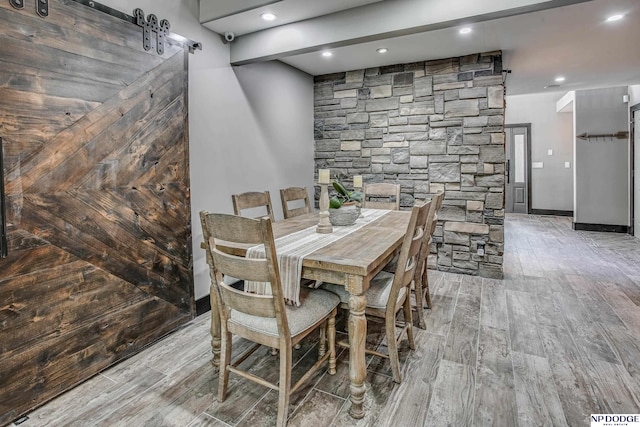 dining space featuring recessed lighting, a barn door, and wood finished floors