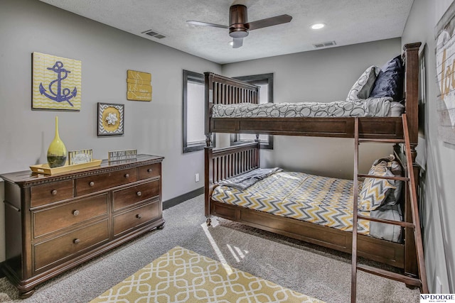 bedroom featuring visible vents, carpet flooring, a textured ceiling, and baseboards