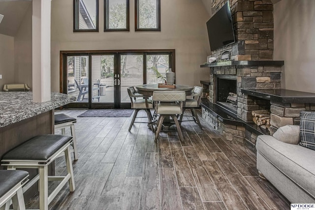 dining room with french doors, high vaulted ceiling, dark wood finished floors, and a fireplace