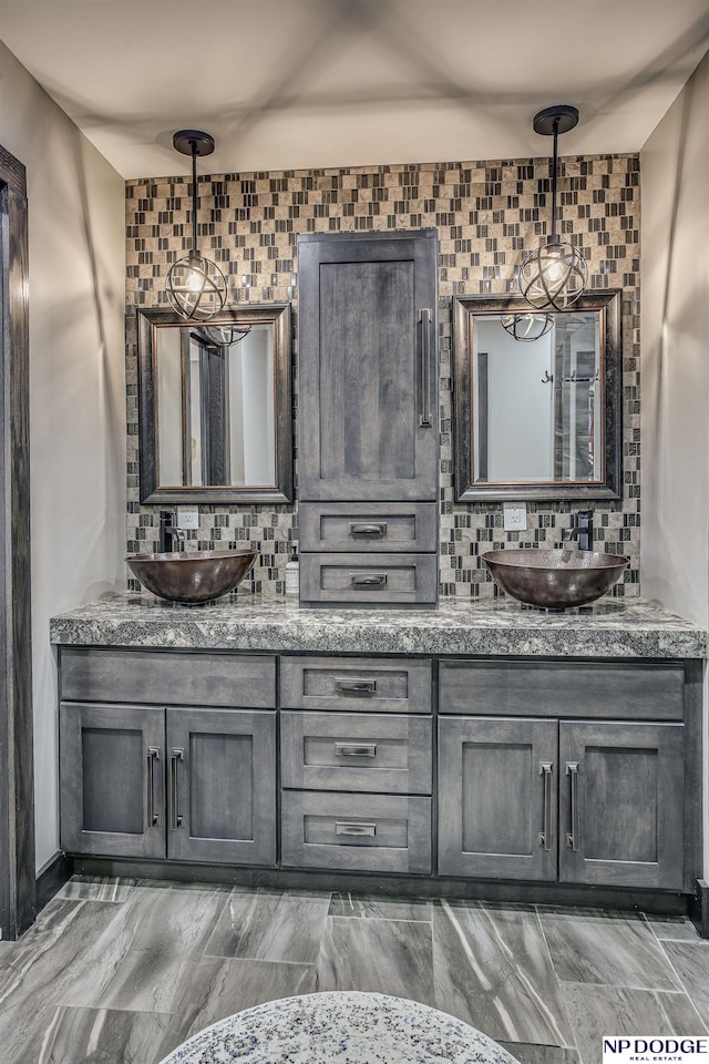 bathroom featuring decorative backsplash, double vanity, and a sink