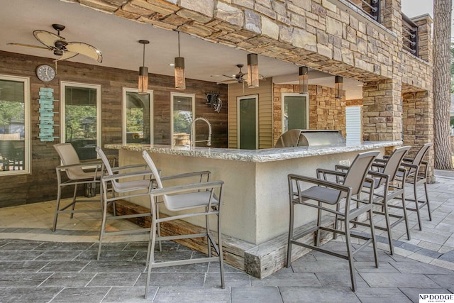 view of patio / terrace with outdoor wet bar, area for grilling, and a ceiling fan