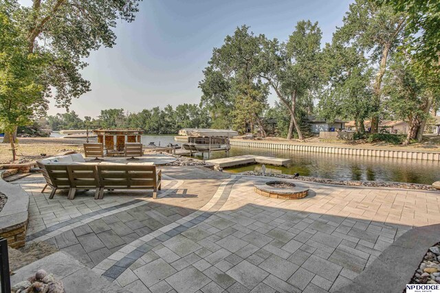 view of patio with a water view and a dock