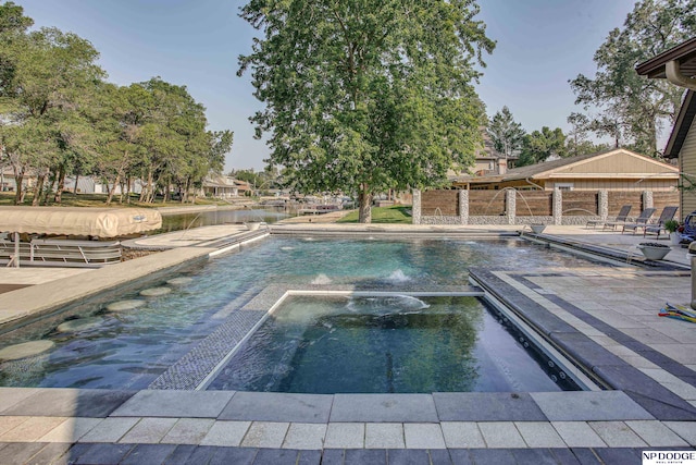 view of pool with a patio, a pool with connected hot tub, and fence