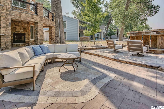 view of patio with an outdoor living space with a fireplace