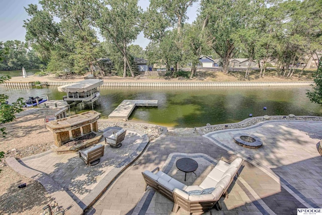 exterior space featuring an outdoor fire pit and a water view