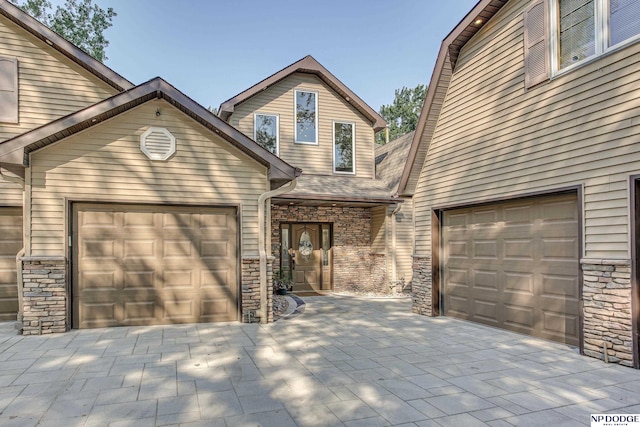 view of front of property featuring stone siding and an attached garage