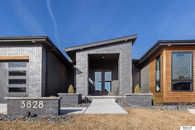 doorway to property with brick siding and french doors