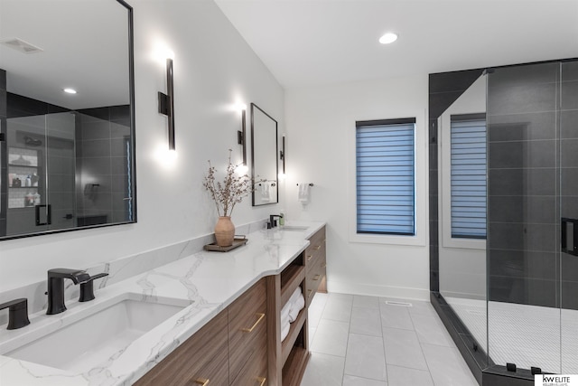 bathroom featuring a shower stall, double vanity, visible vents, and a sink