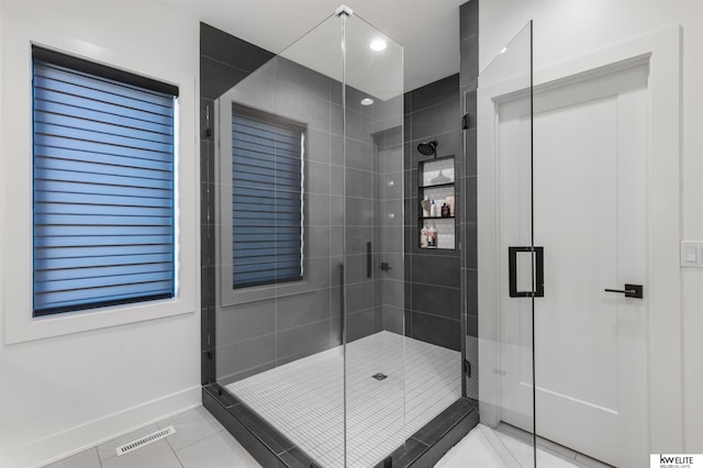 bathroom featuring visible vents, baseboards, a shower stall, and tile patterned flooring