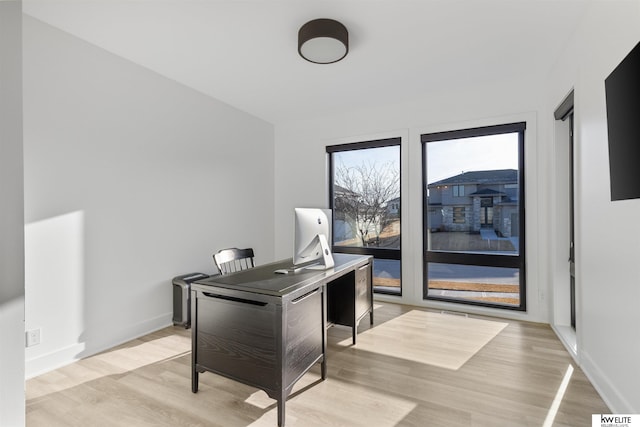 office space featuring light wood-type flooring and baseboards