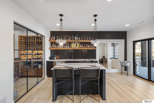 wine cellar with wet bar, recessed lighting, visible vents, and light wood-type flooring