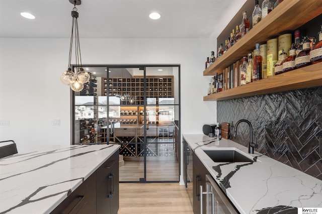 kitchen featuring a sink, open shelves, recessed lighting, light wood finished floors, and hanging light fixtures