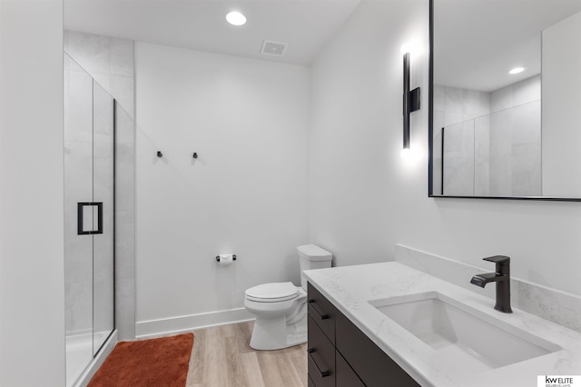 bathroom with visible vents, wood finished floors, a stall shower, and vanity