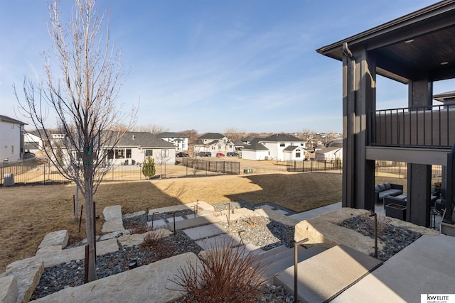 view of yard featuring a patio area, a residential view, and a fenced backyard