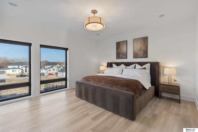 bedroom with light wood-type flooring and baseboards