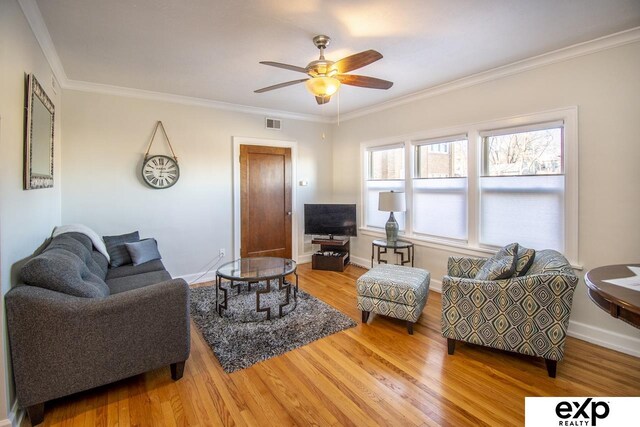 living area with ceiling fan, wood finished floors, visible vents, and ornamental molding