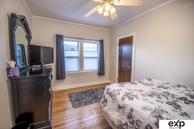 bedroom featuring ceiling fan, baseboards, wood finished floors, and crown molding