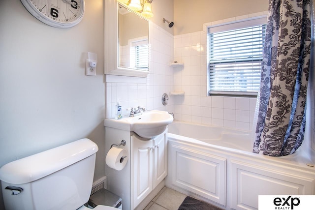 bathroom with plenty of natural light, toilet, shower / tub combo with curtain, and a sink