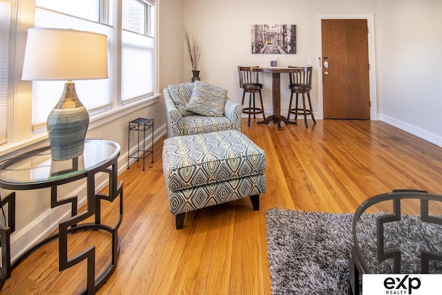 living area with baseboards and wood finished floors