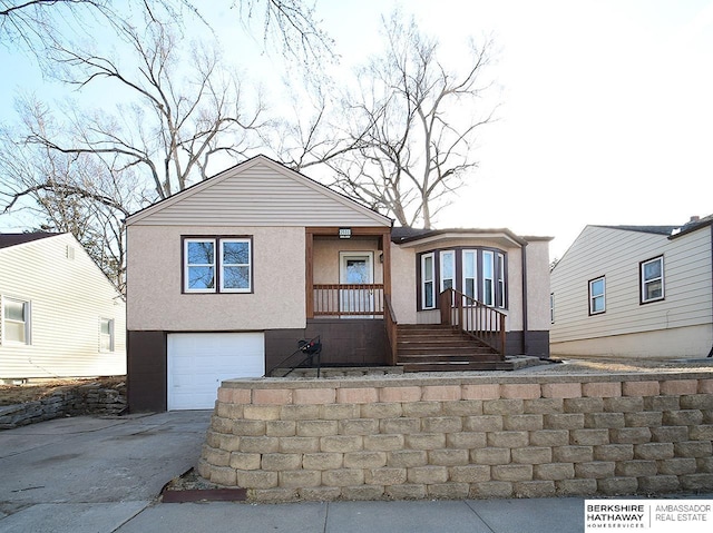 view of front of house featuring stucco siding, concrete driveway, and a garage