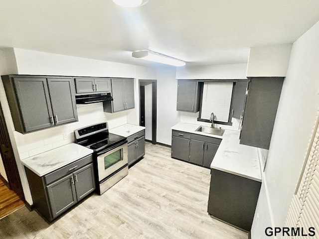 kitchen with light wood-style flooring, a sink, range hood, light countertops, and stainless steel electric range oven