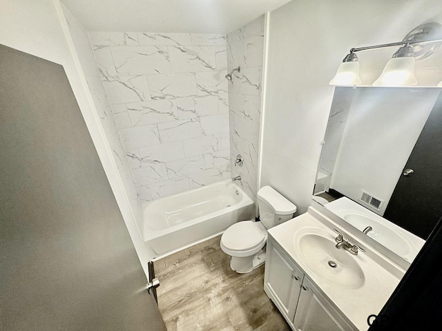 bathroom with visible vents, toilet, shower / bathtub combination, wood finished floors, and vanity