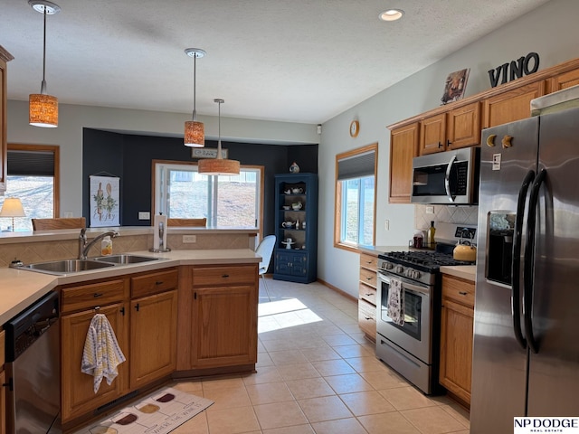 kitchen with light tile patterned floors, decorative backsplash, light countertops, appliances with stainless steel finishes, and brown cabinets