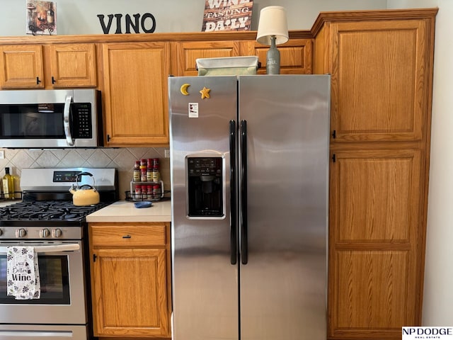 kitchen with decorative backsplash, brown cabinets, appliances with stainless steel finishes, and light countertops