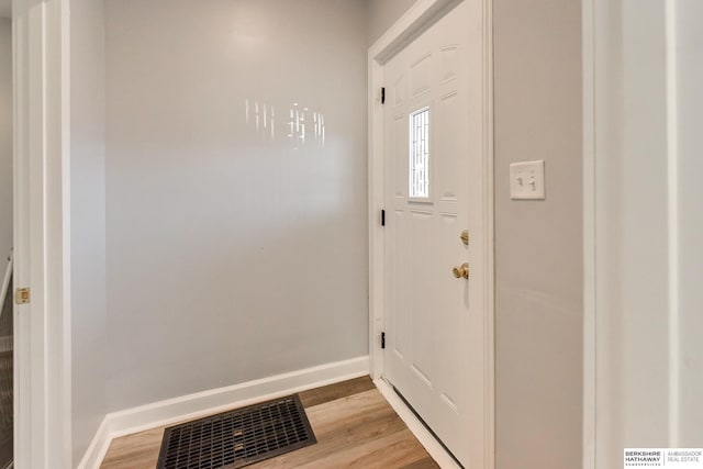 foyer featuring light wood finished floors, visible vents, and baseboards