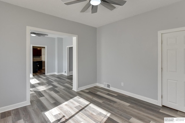 spare room with visible vents, ceiling fan, baseboards, and wood finished floors