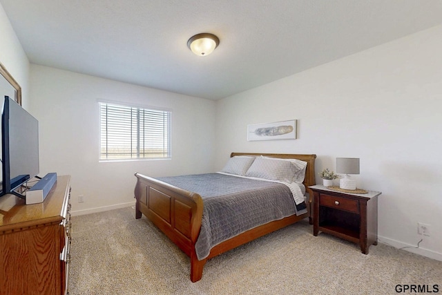 bedroom with baseboards and light carpet