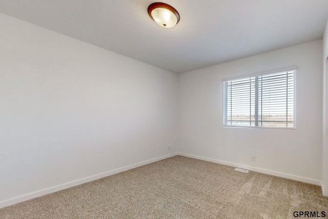 unfurnished room featuring baseboards and light carpet