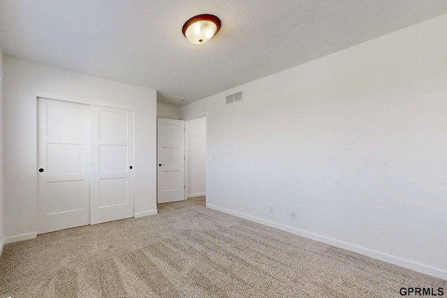 unfurnished bedroom with a closet, baseboards, visible vents, and carpet floors