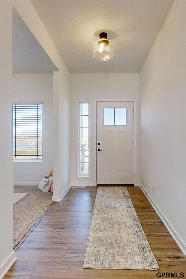 entryway with dark wood-style floors and baseboards