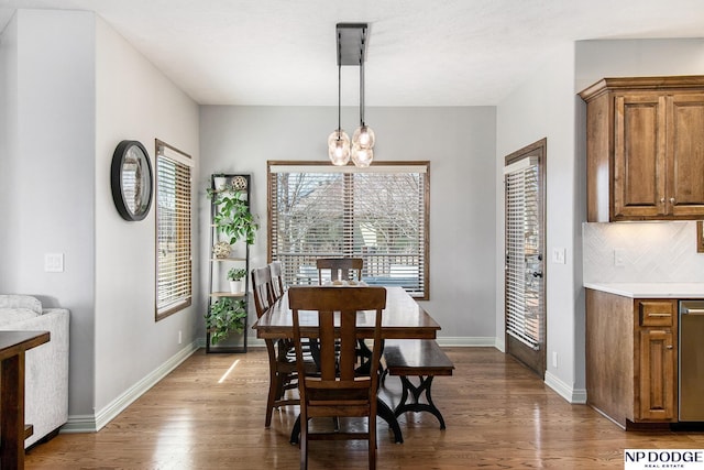 dining space featuring a notable chandelier, wood finished floors, and baseboards