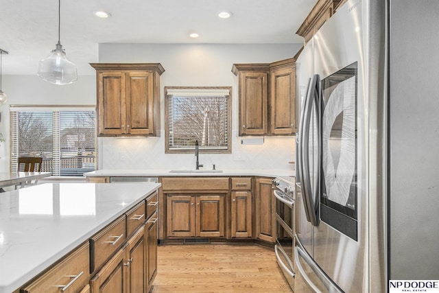 kitchen with a sink, appliances with stainless steel finishes, and brown cabinetry