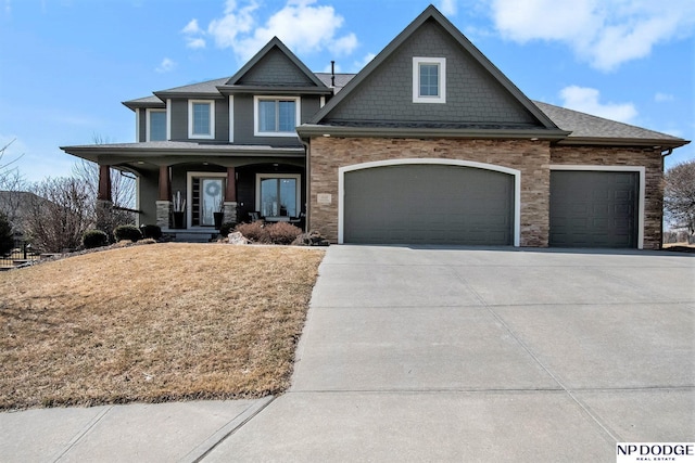 craftsman-style home featuring a porch, driveway, a front yard, and a garage