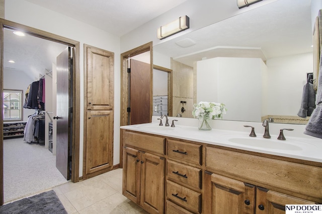 bathroom featuring tile patterned flooring, double vanity, and a sink