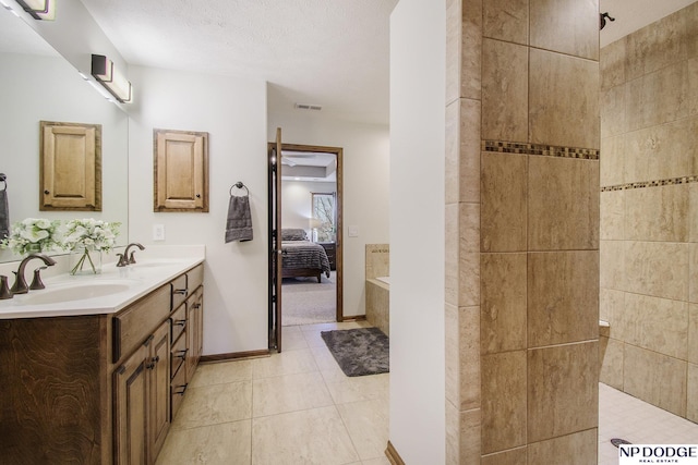 full bath with visible vents, a walk in shower, double vanity, ensuite bathroom, and a sink