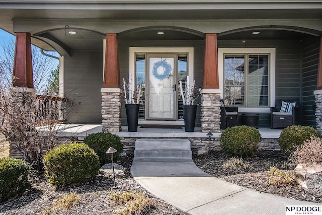 property entrance with stone siding and a porch