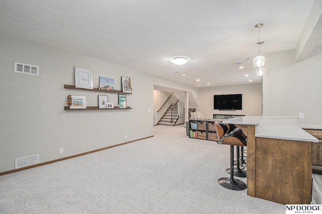 interior space featuring stairway, baseboards, visible vents, and light carpet