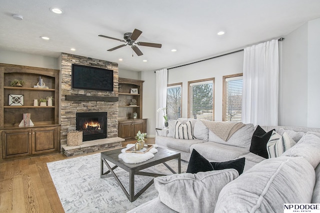 living room with recessed lighting, light wood-type flooring, ceiling fan, and a fireplace