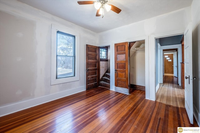 unfurnished bedroom with hardwood / wood-style flooring, baseboards, a closet, and ceiling fan