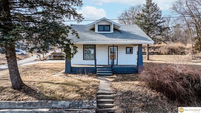 bungalow-style house featuring covered porch and a shingled roof